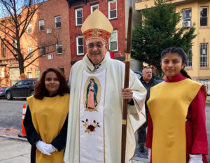 Bishop DiMarzio taking a picture with two women